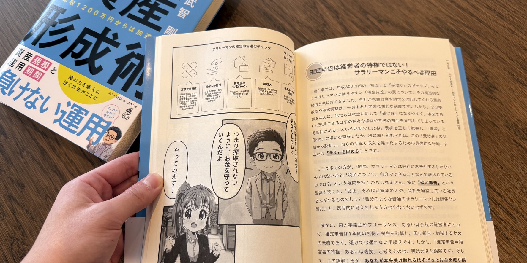 自社で制作した紙書籍『年収600万円からの資産形成術』の現物。漫画と本文が入った見開きページを手に持っている